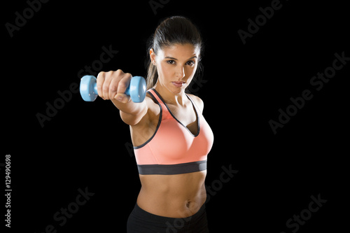  latin sport woman posing in fierce expression holding dumbbell hand weigh