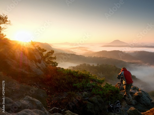 Happy photo enthusiast  enjoy  photography of  fall daybreak in nature on cliff