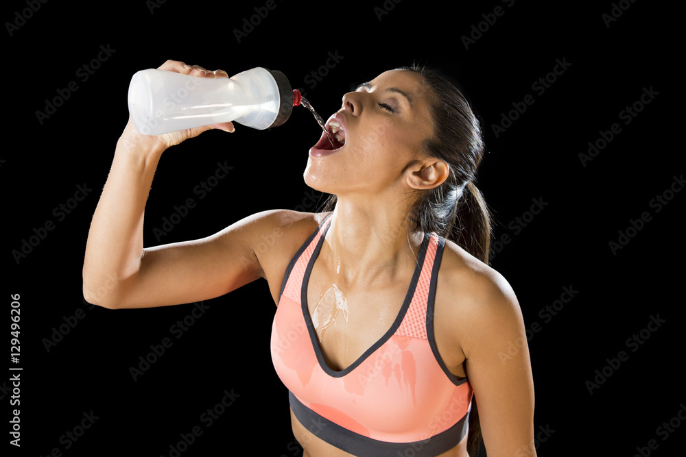  beautiful and fit latin sport woman drinking water tired during training workout