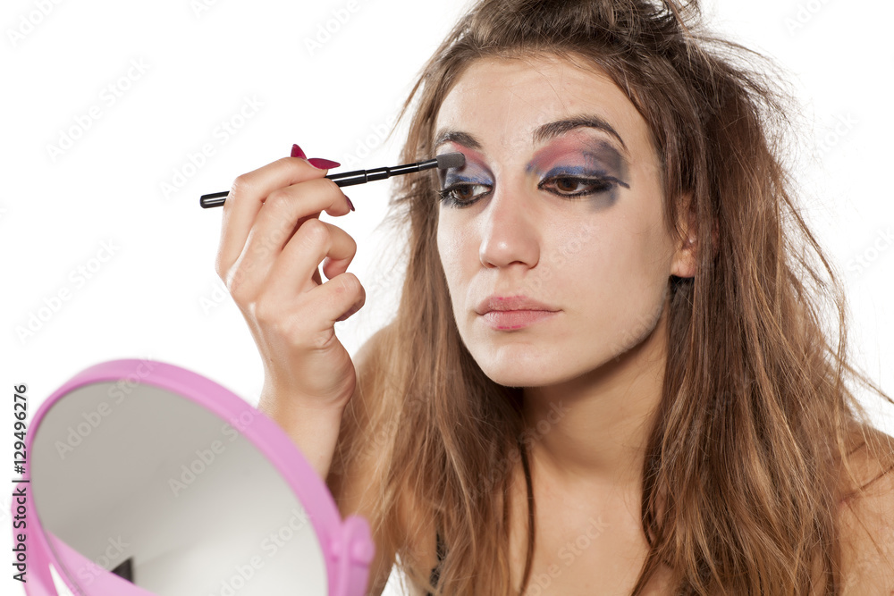 Fototapeta premium young woman in a mirror and ugly makeup