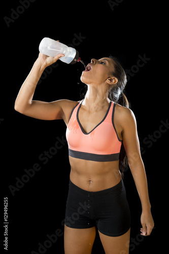  beautiful and fit latin sport woman drinking water tired during training workout