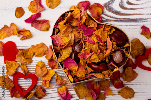Heart-shaped box with rose potpourri. Chestnuts  dried petals and hearts. Design on day of love.