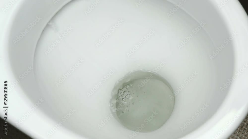 Flushing the water into the toilet bowl. Draining the water into the