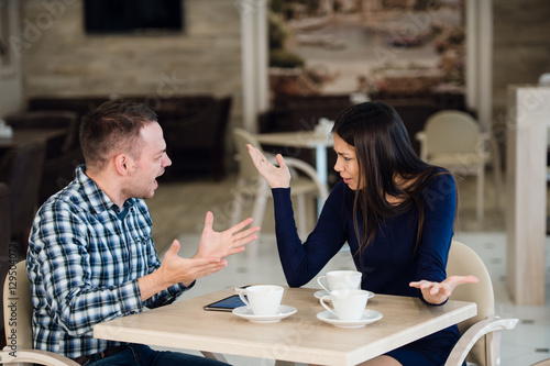 Foto Young couple arguing in a cafe