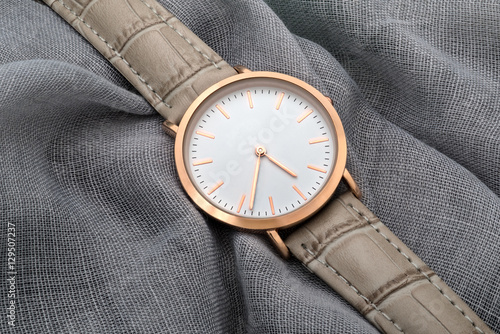 Wrist watch on gray silk fabric background
