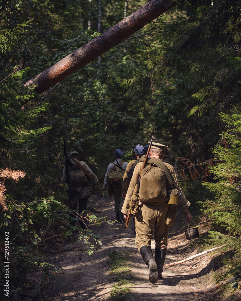 Historical reenactment of Russian Civil war in the Urals in 1918. Soldier of White Army goes on a forest road