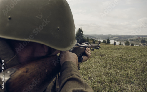 PERM, RUSSIA - JULY 30, 2016: Historical reenactment of World War II, summer, 1942. Soviet soldier aiming a rifle