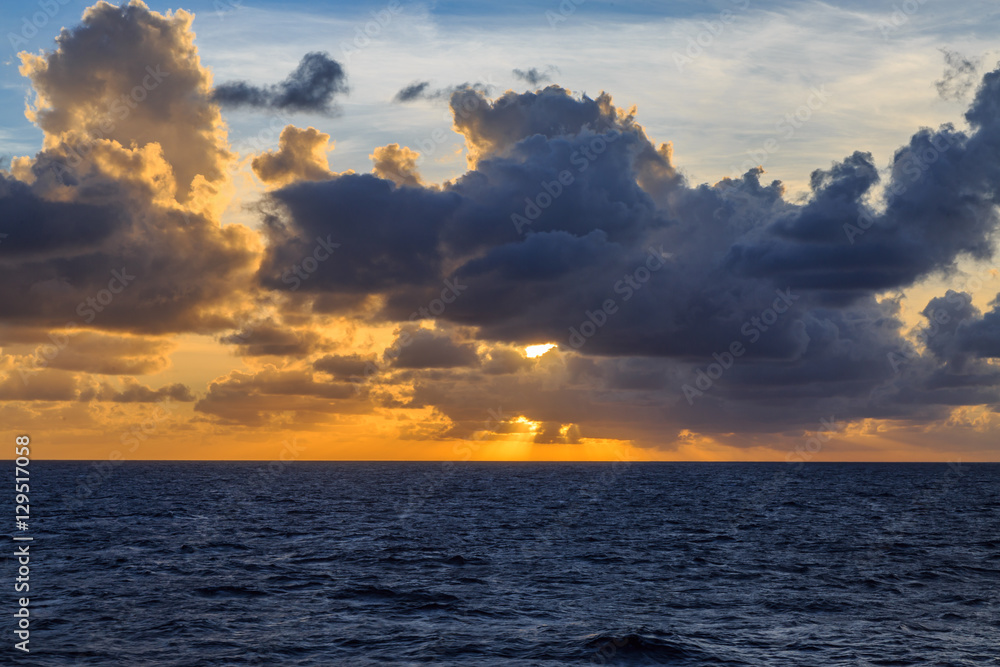 Fototapeta premium Sun among clouds over the ocean.