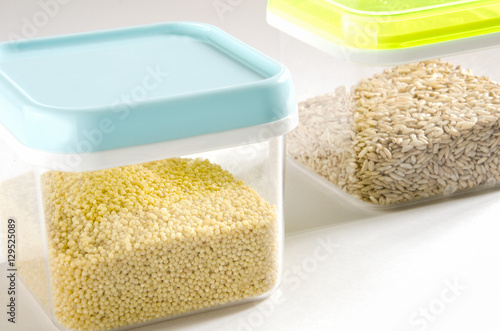 Food storage. Food ingredients (millet and wild rice) in plastic containers. Selective focus.