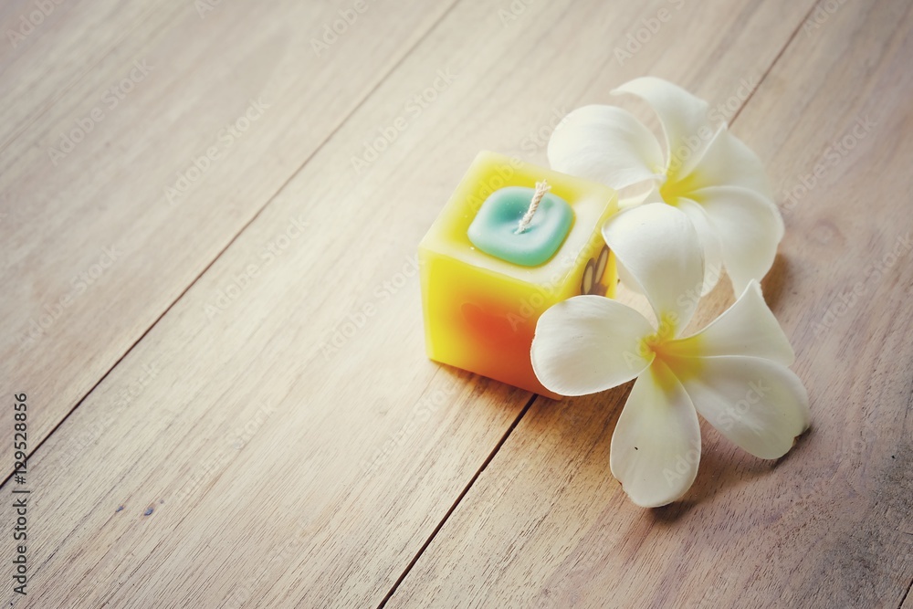 Soft focus candles and frangipani flowers on a wooden background. spa and relaxation concept. retro tone. Copy space. Soft focus candles and frangipani flowers on a wooden background. spa and relaxation concept. retro tone. Copy space.