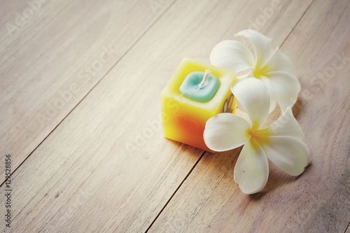 Soft focus candles and frangipani flowers on a wooden background. spa and relaxation concept. retro tone. Copy space.
