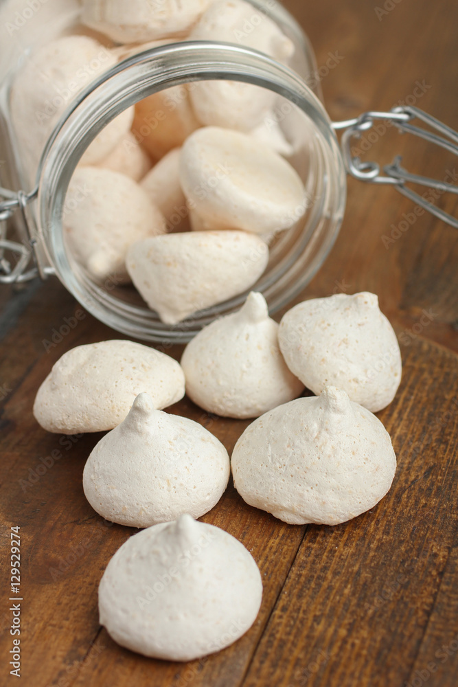 Coconut meringue in a glass jar on a wooden background. Coconut meringue in a glass jar on a wooden background.