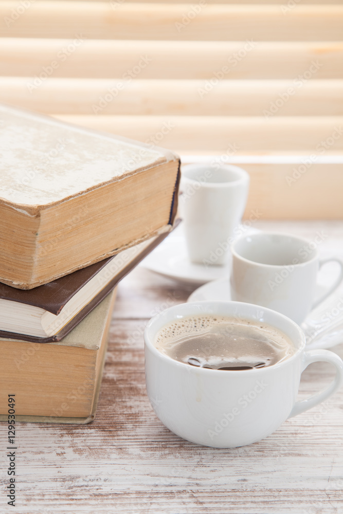 Office workplace with  coffee cup on wooden desk table in front of window with blinds, selective focus