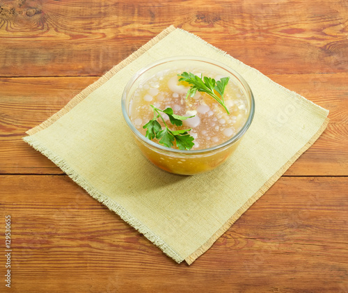 Pork aspic in glass bowl on a old wooden surface photo