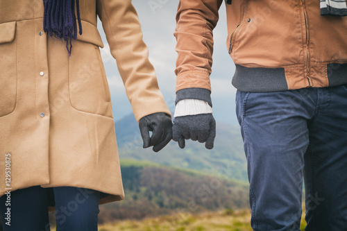 Couple holding hands outdoors.