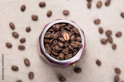 Italian moka pot full of roasted coffee beans. Top view