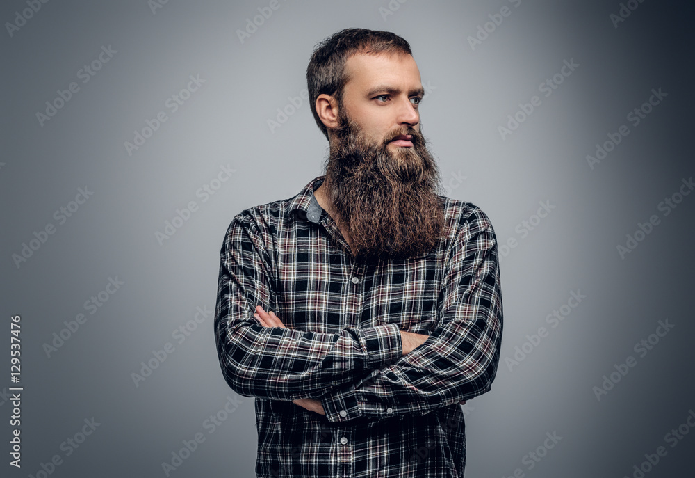 Bearded male with crossed arms, dressed in a plaid shirt. Bearded male with crossed arms, dressed in a plaid shirt.