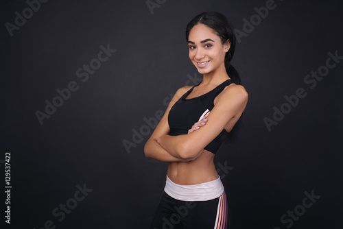 Smiling charming girl holding hands crossed on chest