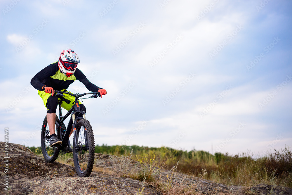 Professional Cyclist Riding the Bike Down Rocky Hill. Extreme Sport. Space for Text. Professional Cyclist Riding the Bike Down Rocky Hill. Extreme Sport. Space for Text.