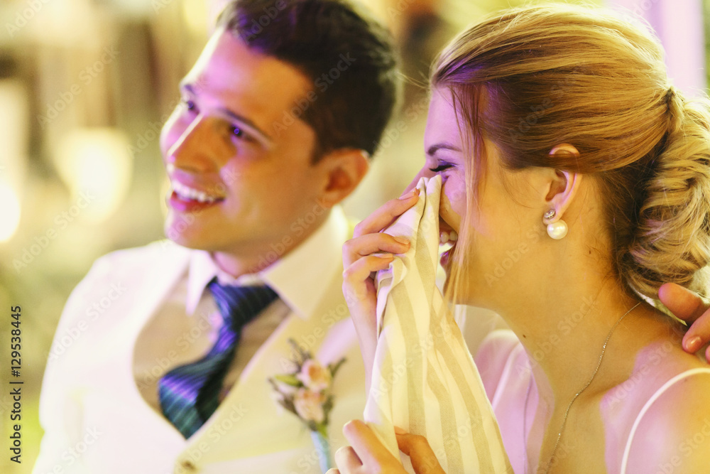 Naklejka premium Happy crying wedding couple sits at the dinner table