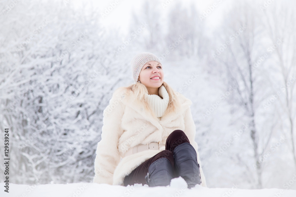 Woman wearing soft fur coat and enjoying a beautiful winter day and fresh air in the park. Woman wearing soft fur coat and enjoying a beautiful winter day and fresh air in the park.