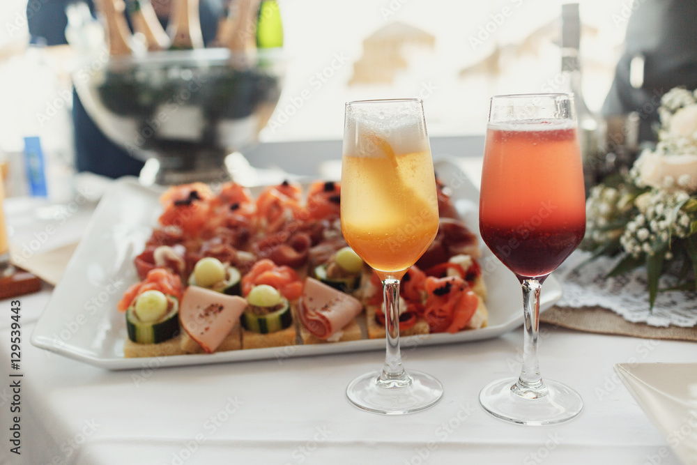 Champagne flutes with fruits stand on dinner table Champagne flutes with fruits stand on dinner table