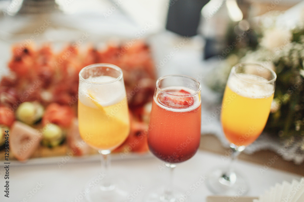 Champagne flutes with fruits stand on dinner table with snacks Champagne flutes with fruits stand on dinner table with snacks