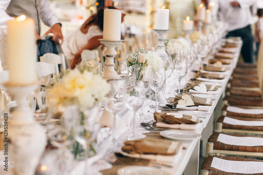 White plates stand in the row on flaxen tablecloth