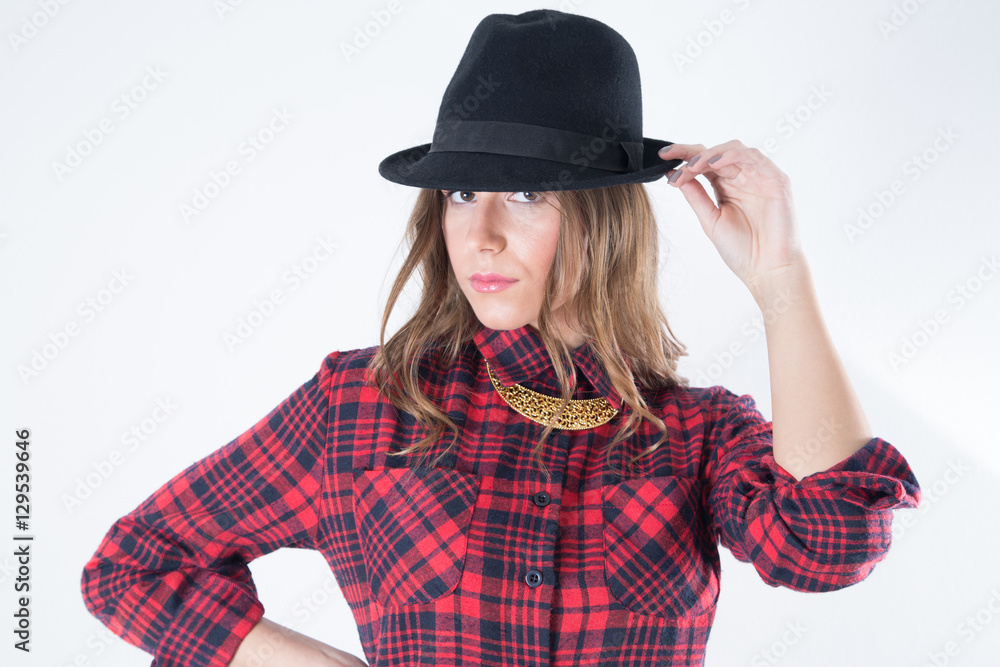 Closeup Portrait Of Fashionable Woman In Red Woolen Plaid Shirt With Black Hat And Golden Necklace Looking At The Camera, Studio Shot Against White Background Closeup Portrait Of Fashionable Woman In Red Woolen Plaid Shirt With Black Hat And Golden Necklace Looking At The Camera, Studio Shot Against White Background