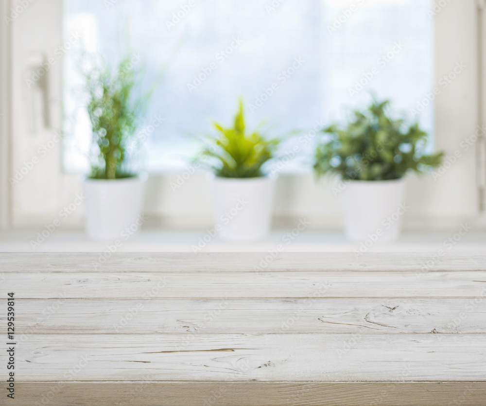Wooden table on blurred spring window with plant pots background Wooden table on blurred spring window with plant pots background