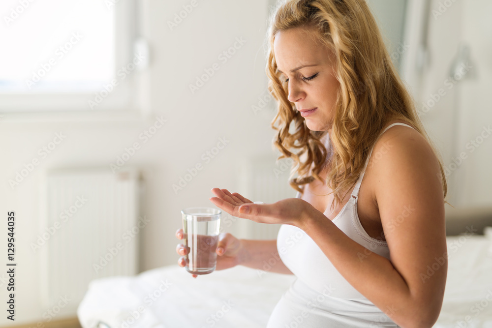 Pregnant woman taking pill Pregnant woman taking pill