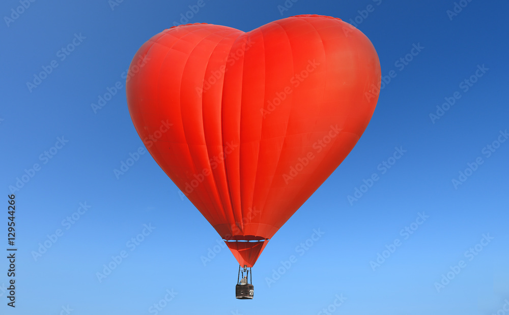 Fototapeta premium Red balloon in the shape of a heart against the blue sky