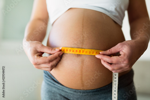 Pregnant woman measuring belly diameter