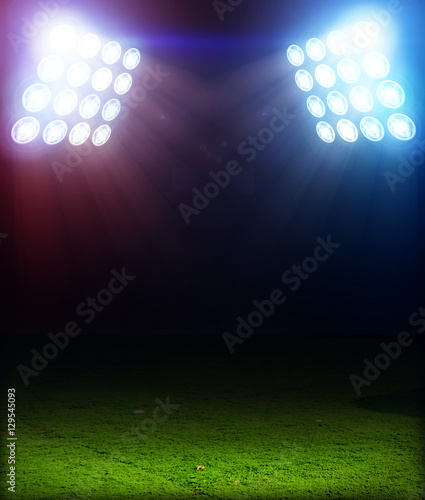 Green soccer field, bright spotlights, illuminated stadium