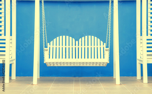 white wood swing on blue background , vintage tone photo