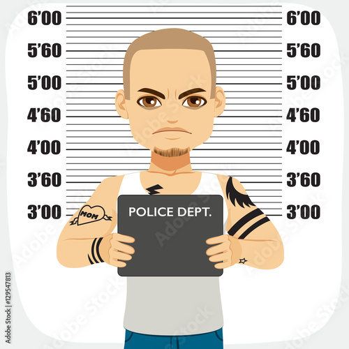 Dangerous male criminal with tattoos holding mugshot