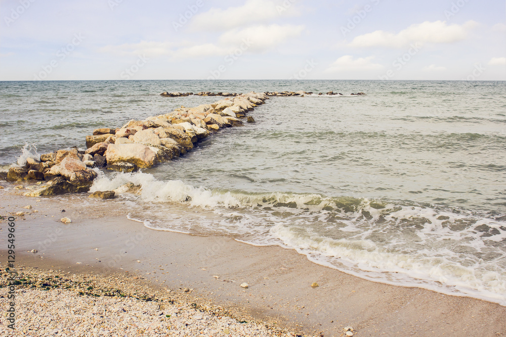 Sea view with a long stone pier at the Adriatic Sea shores