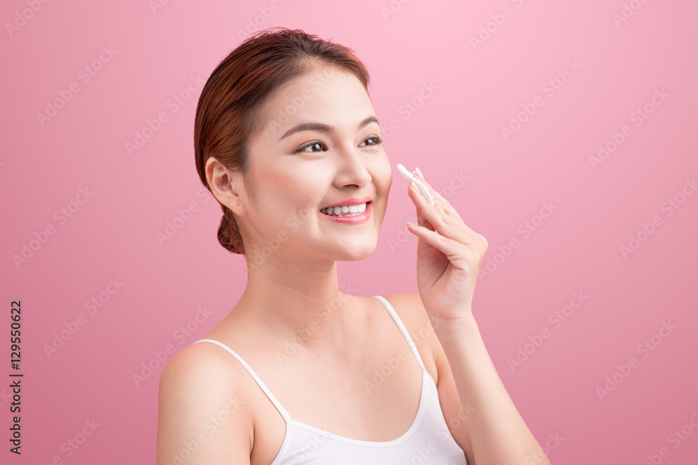 Gorgeous young woman holding cotton pad and smiling in taking ca Gorgeous young woman holding cotton pad and smiling in taking ca