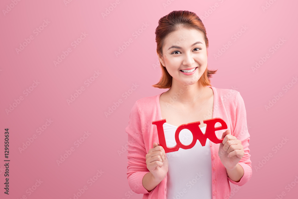 Pretty asian young woman holding wooden letters LOVE on link bac Pretty asian young woman holding wooden letters LOVE on link bac