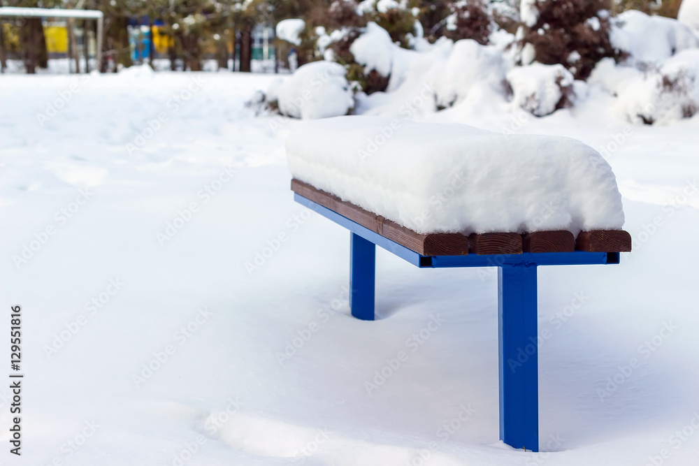 Wooden bench covered by snow in winter day. Wooden bench covered by snow in winter day.