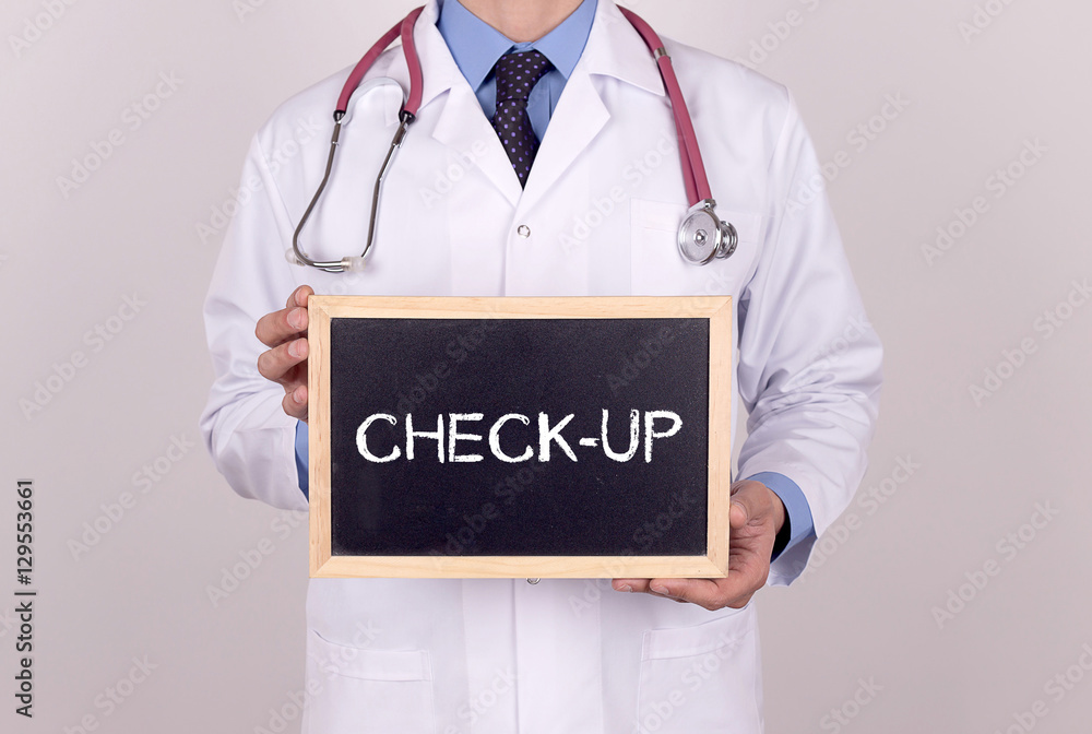 Doctor holding mini blackboard with CHECK-UP message Doctor holding mini blackboard with CHECK-UP message