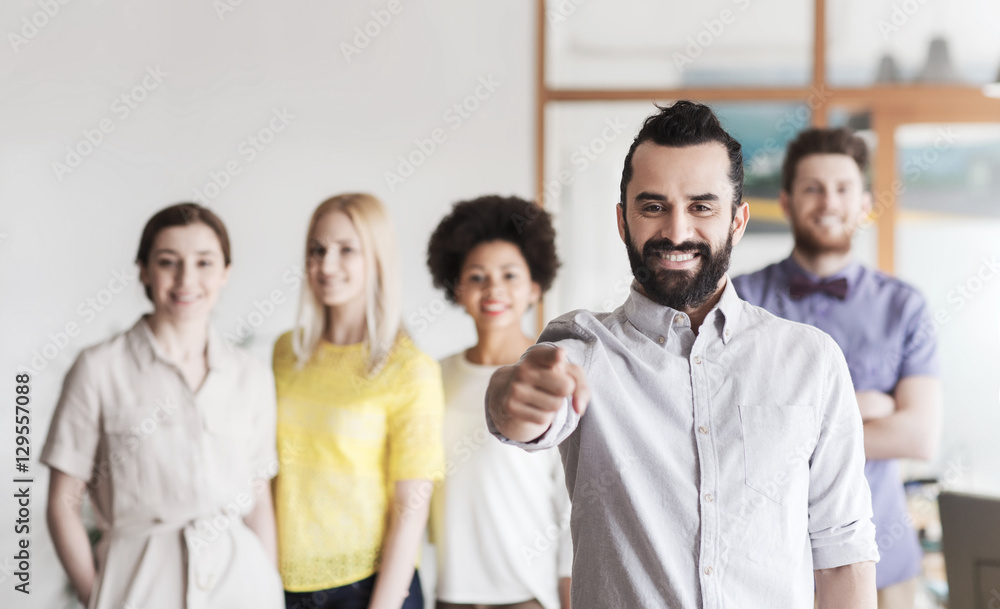 happy man pointing finger at you over office team happy man pointing finger at you over office team