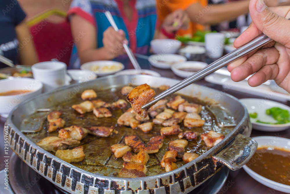 Obraz premium delicious grilled pork barbecue, meat are being cooked on stove