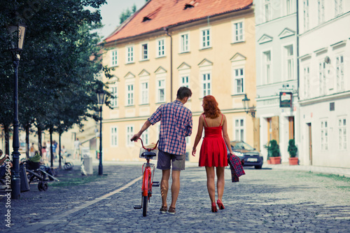Couple in Red Walking on the Street with Bike in old town in Pra © Anastasiia Krivenok
