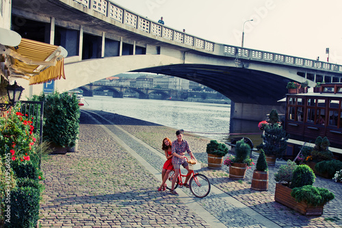 Couple in Red Walking on the Street with Bike in old town in Pra photo