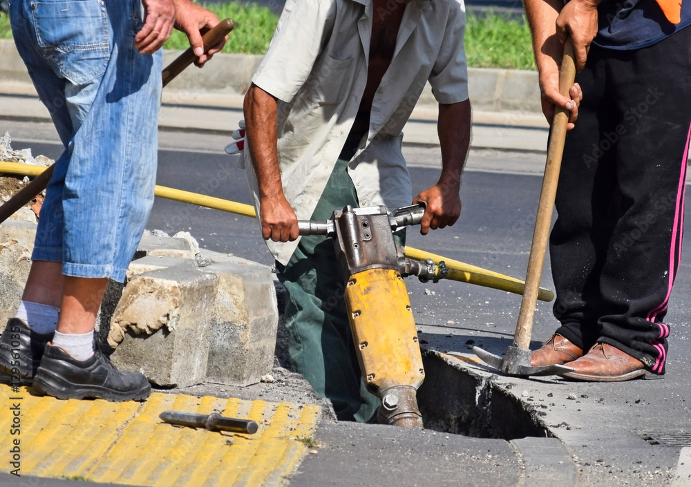 Construction workers with air hammer