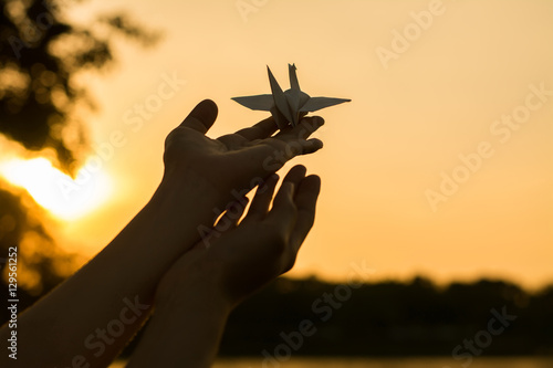 Silhouette people pray from Buddha statue to hope for help on sun set and bokeh background. Inspiration from help to hope, Put the palms of the hands together in salute.Silhouette of one helping hand,