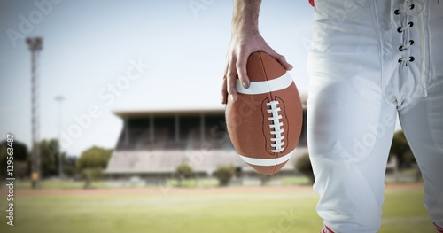 Composite image of american football player holding football