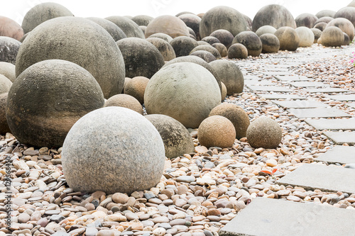 Stone sphere in garden with footpath