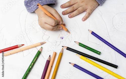 close up children drawing with clolored pencils on paper. photo